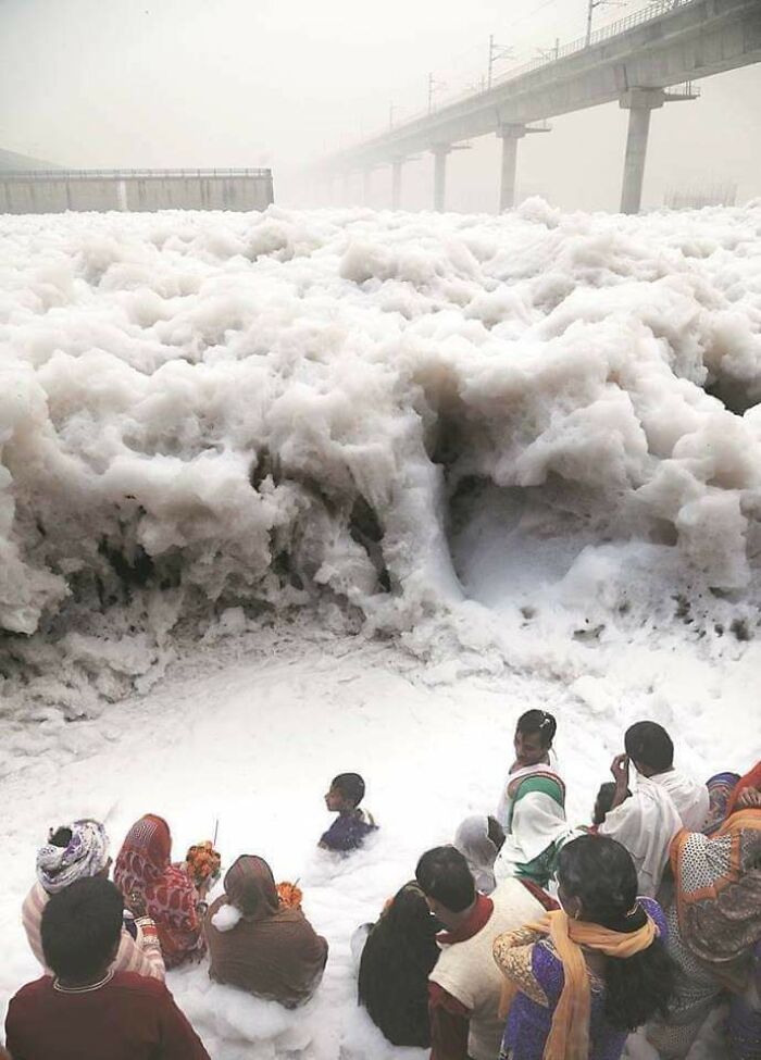 Yamuna Nehri, Hindistan’da, endüstriyel atıkların tam ortasında dua eden insanları gösteren bir resim