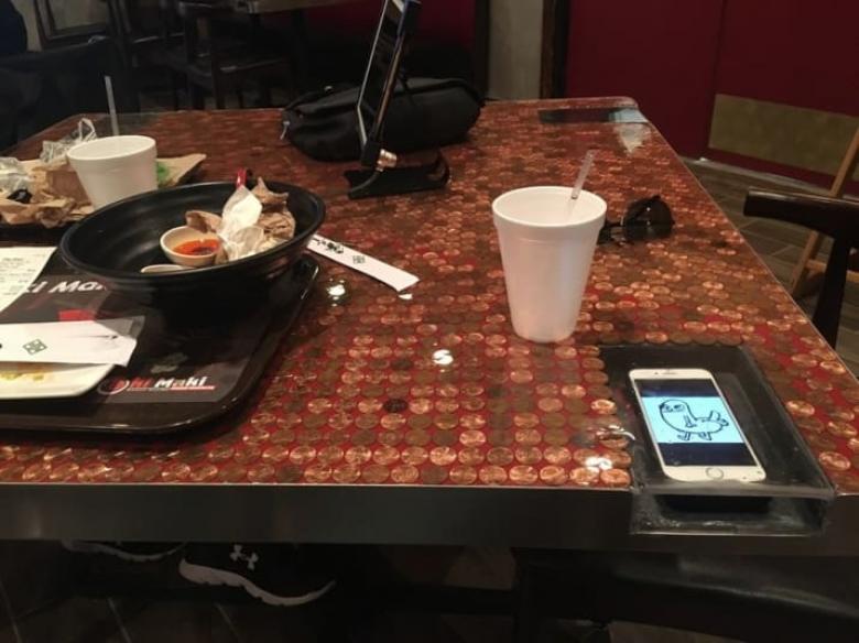 2. Akıllı telefonların güvenli bir şekilde koyabileceğiniz bir bölmesi olan yemek masası.