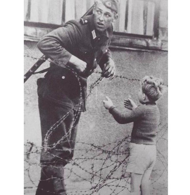 Yıl 1961 - Doğu Alman askeri, çocuğu ailesi ile kavuşturmak için Berlin Duvarı'ndan geçmesini sağlıyor.