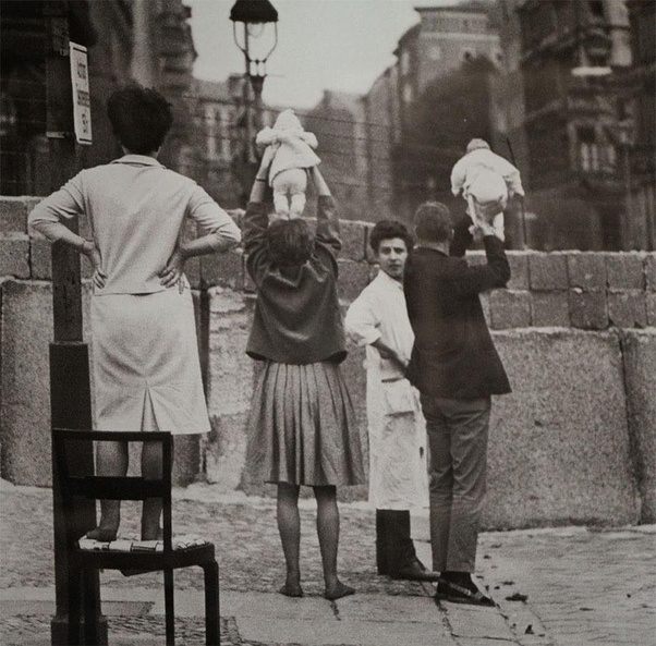 21. Doğu Berlin'deki ebeveynlerine duvarın üzerinden torunlarını gösteren Batı Berlinli çift.