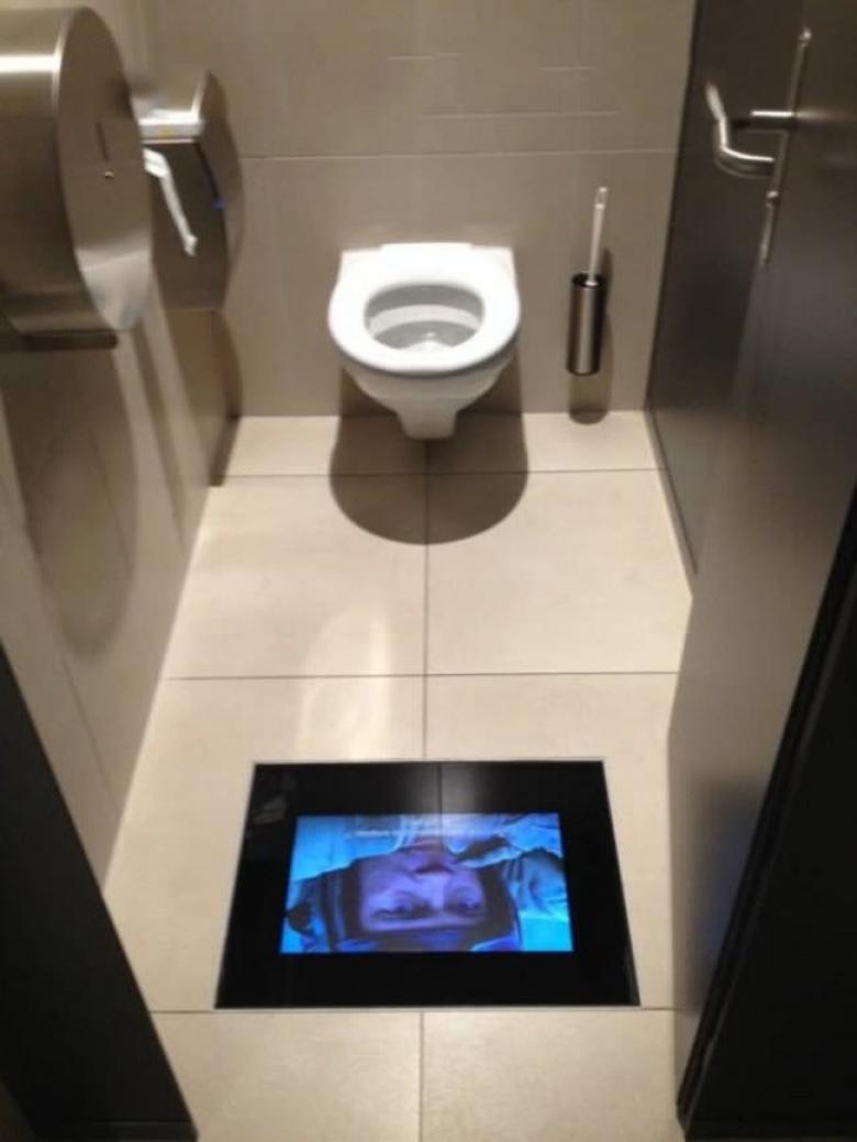 Bir sinemanın tuvaletinde yerdeki ekranlardan filme kaldığınız yerden devam edebilirsiniz.
