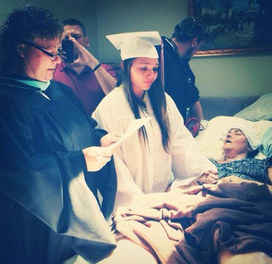 12. Bir kız üniversite diplomasını, hasta annesinin yatağının yanında alıyor.